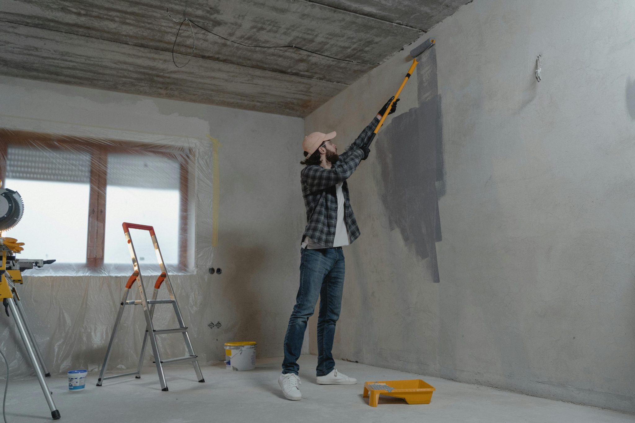 Werker voert renovatie woning Amsterdam uit met moderne gereedschappen in een oud gebouw